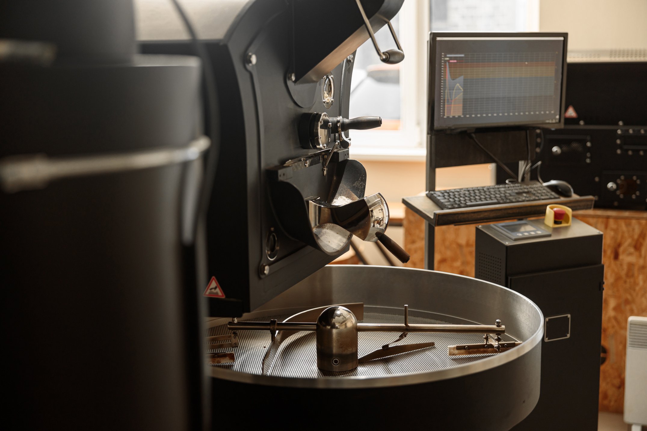 Coffee Processing. Roastery, Roasting Machine and Fresh Beans